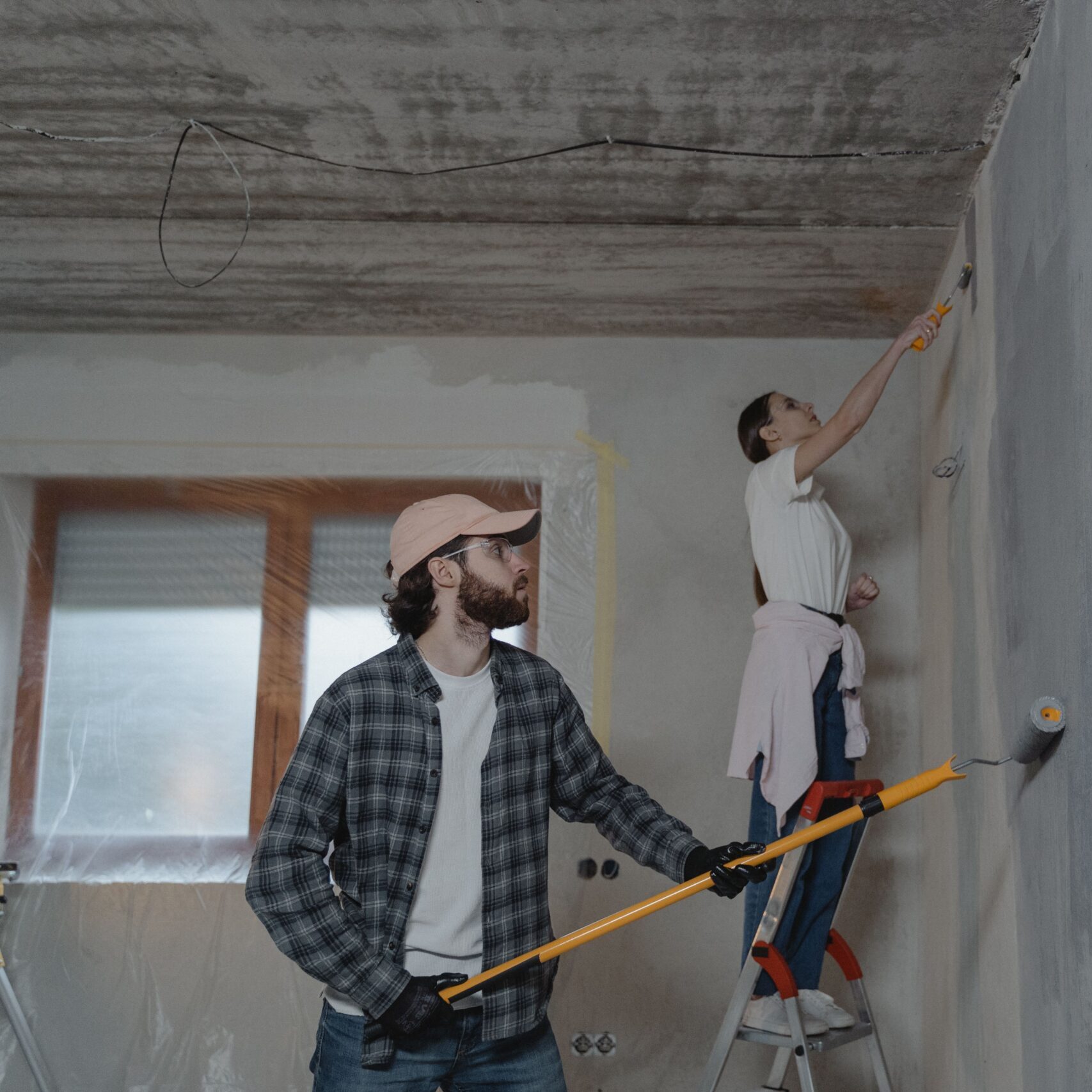 A couple painting a room together, highlighting teamwork in home renovation.